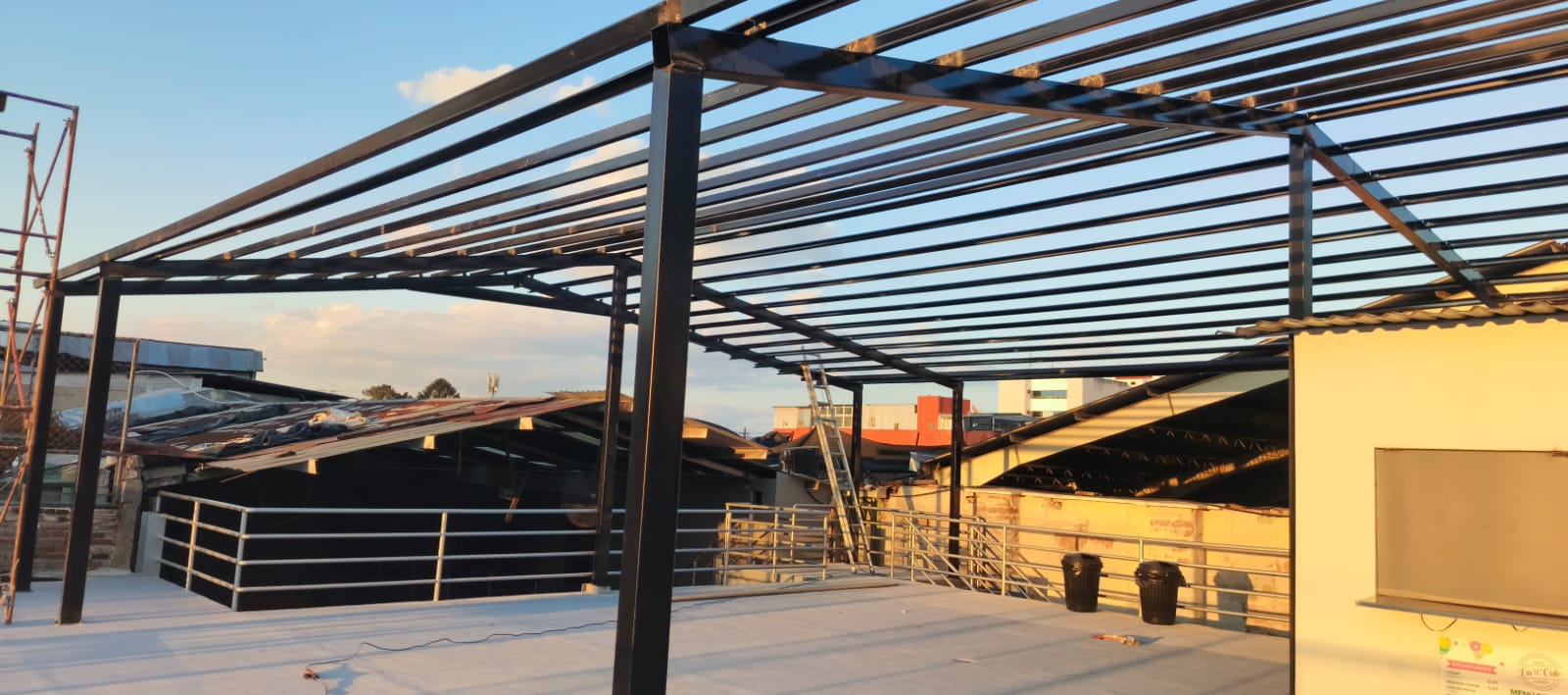 Columnas y travesaños de una estructura metálica negra en montaje sobre una terraza