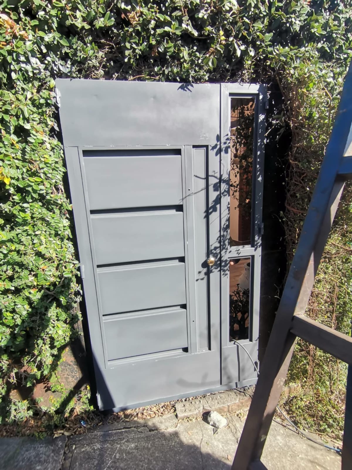 Puerta gris de paneles horizontales con sección lateral, antes de instalar